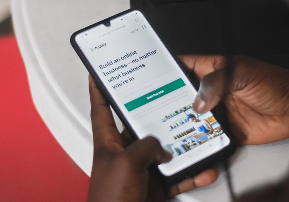 Photograph of person viewing the Shopify website on a mobile phone.