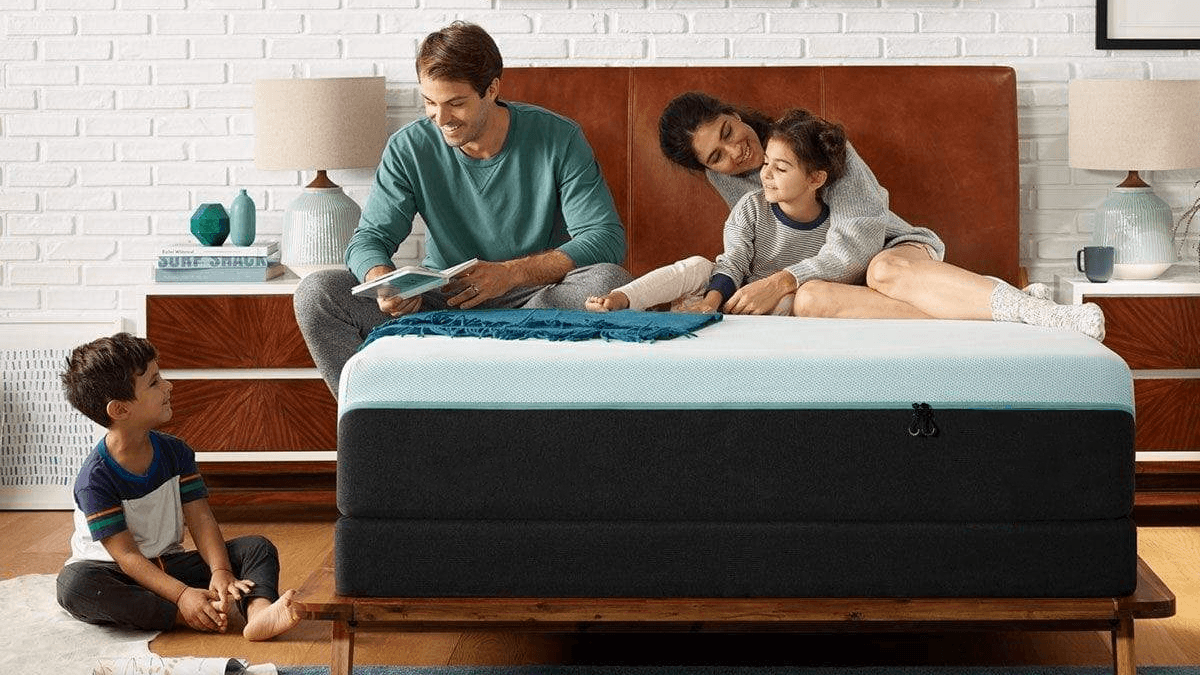 A happy family sitting on a bed in a stylishly decorated bedroom.