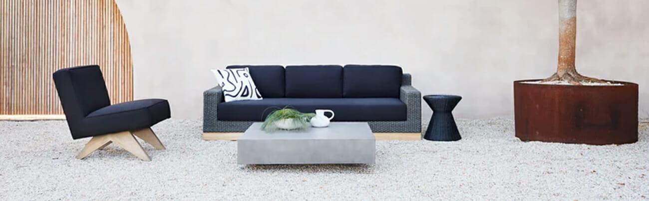 Image of a modern outdoor living space with a sofa and lounge chair.