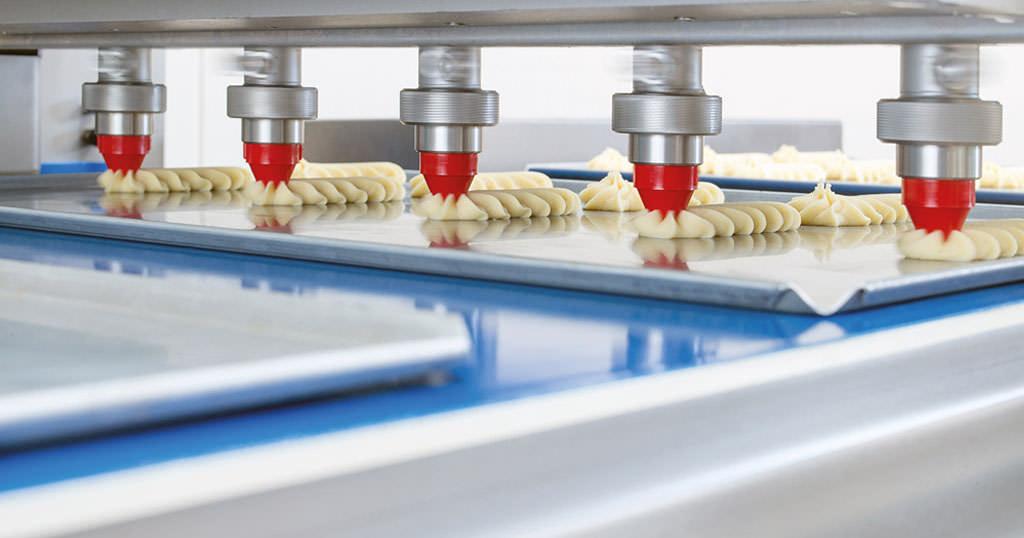 Image of a manufacturing line pumping out baking batter onto a baking dish.