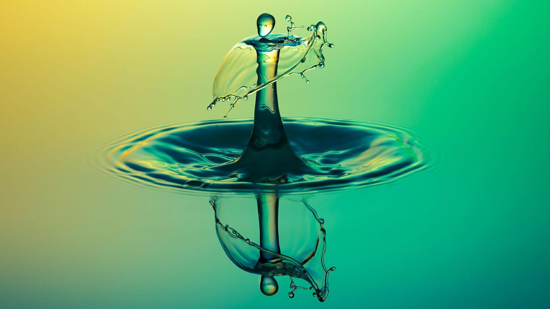 Closeup of water droplet falling into still water
