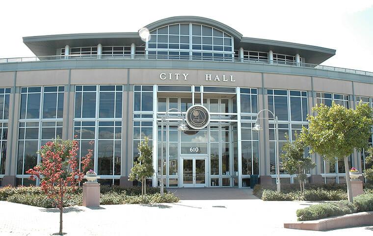 Image of city hall building with glass windows on the front.
